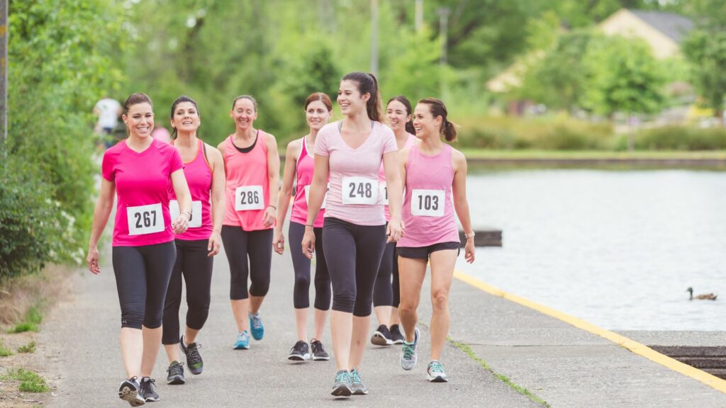 Un groupe de femmes portant toutes un t-shirt rose et faisant une course à l'occasion d'Octobre Rose